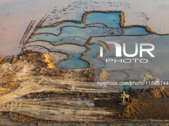 Workers work at the Qingjiangpu section of the second phase of the Huaihe River Waterway project in Huai 'an City, Jiangsu Province, on Dece...