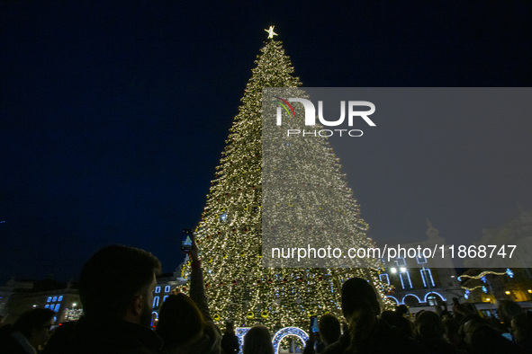 People gather around the Christmas lights at Praca do Comercio in Lisbon, Portugal, on December 14, 2024. The Christmas lights in Lisbon are...