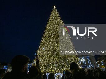 People gather around the Christmas lights at Praca do Comercio in Lisbon, Portugal, on December 14, 2024. The Christmas lights in Lisbon are...