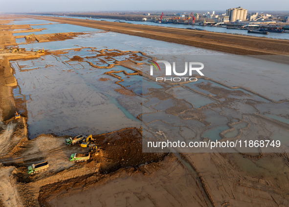 Workers work at the Qingjiangpu section of the second phase of the Huaihe River Waterway project in Huai 'an City, Jiangsu Province, on Dece...