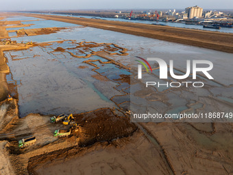 Workers work at the Qingjiangpu section of the second phase of the Huaihe River Waterway project in Huai 'an City, Jiangsu Province, on Dece...