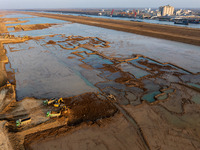 Workers work at the Qingjiangpu section of the second phase of the Huaihe River Waterway project in Huai 'an City, Jiangsu Province, on Dece...