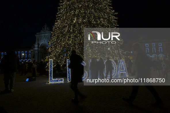 People gather around the Christmas lights at Praca do Comercio in Lisbon, Portugal, on December 14, 2024. The Christmas lights in Lisbon are...