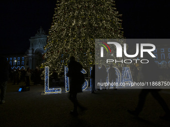 People gather around the Christmas lights at Praca do Comercio in Lisbon, Portugal, on December 14, 2024. The Christmas lights in Lisbon are...