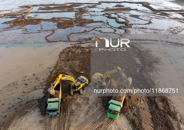 Workers work at the Qingjiangpu section of the second phase of the Huaihe River Waterway project in Huai 'an City, Jiangsu Province, on Dece...