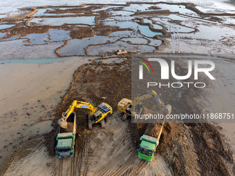 Workers work at the Qingjiangpu section of the second phase of the Huaihe River Waterway project in Huai 'an City, Jiangsu Province, on Dece...