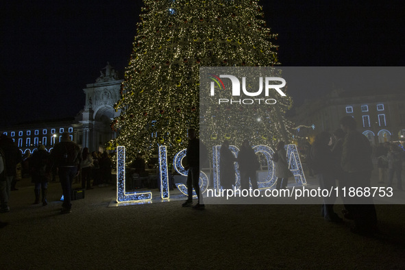 People gather around the Christmas lights at Praca do Comercio in Lisbon, Portugal, on December 14, 2024. The Christmas lights in Lisbon are...