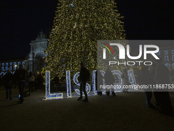 People gather around the Christmas lights at Praca do Comercio in Lisbon, Portugal, on December 14, 2024. The Christmas lights in Lisbon are...