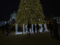 People gather around the Christmas lights at Praca do Comercio in Lisbon, Portugal, on December 14, 2024. The Christmas lights in Lisbon are...