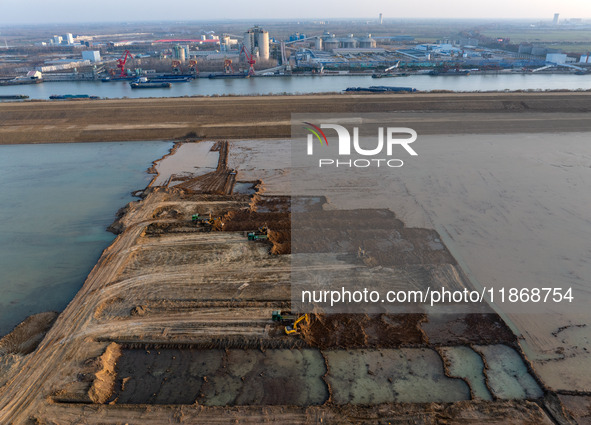 Workers work at the Qingjiangpu section of the second phase of the Huaihe River Waterway project in Huai 'an City, Jiangsu Province, on Dece...