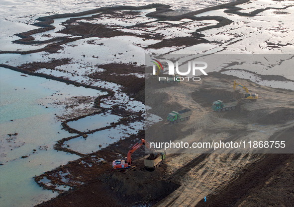 Workers work at the Qingjiangpu section of the second phase of the Huaihe River Waterway project in Huai 'an City, Jiangsu Province, on Dece...