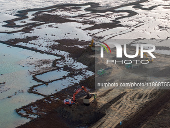 Workers work at the Qingjiangpu section of the second phase of the Huaihe River Waterway project in Huai 'an City, Jiangsu Province, on Dece...