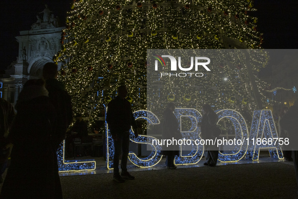 People gather around the Christmas lights at Praca do Comercio in Lisbon, Portugal, on December 14, 2024. The Christmas lights in Lisbon are...