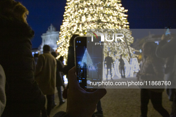 In Lisbon, Portugal, on December 14, 2024, a person takes a picture with a cellphone around the Christmas lights at Praca do Comercio. The C...