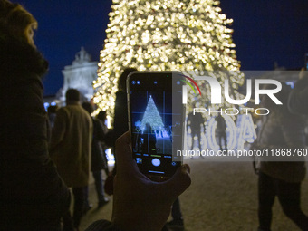 In Lisbon, Portugal, on December 14, 2024, a person takes a picture with a cellphone around the Christmas lights at Praca do Comercio. The C...