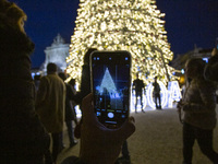 In Lisbon, Portugal, on December 14, 2024, a person takes a picture with a cellphone around the Christmas lights at Praca do Comercio. The C...