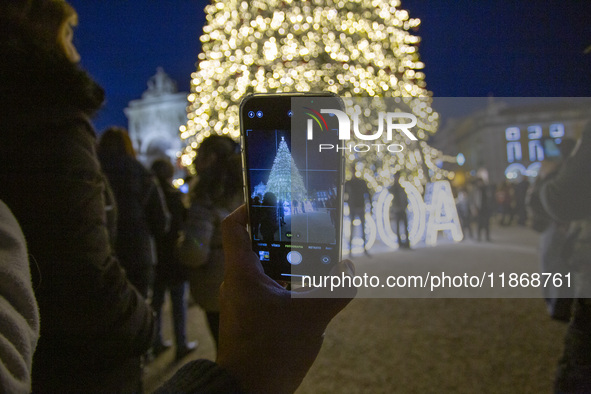 In Lisbon, Portugal, on December 14, 2024, a person takes a picture with a cellphone around the Christmas lights at Praca do Comercio. The C...