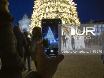 In Lisbon, Portugal, on December 14, 2024, a person takes a picture with a cellphone around the Christmas lights at Praca do Comercio. The C...