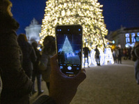 In Lisbon, Portugal, on December 14, 2024, a person takes a picture with a cellphone around the Christmas lights at Praca do Comercio. The C...