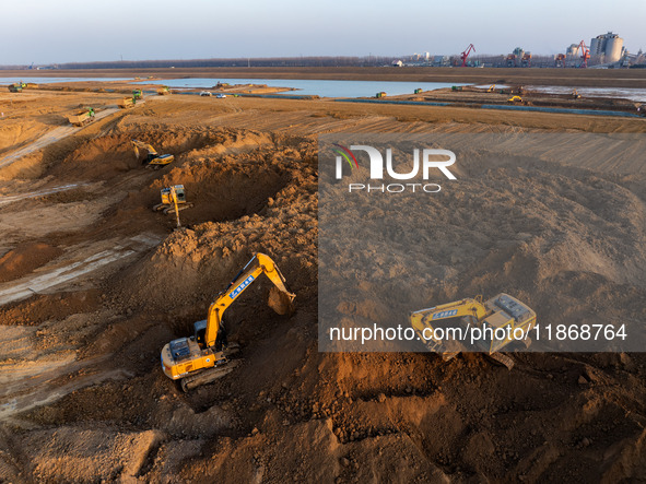 Workers work at the Qingjiangpu section of the second phase of the Huaihe River Waterway project in Huai 'an City, Jiangsu Province, on Dece...