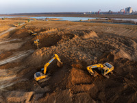 Workers work at the Qingjiangpu section of the second phase of the Huaihe River Waterway project in Huai 'an City, Jiangsu Province, on Dece...