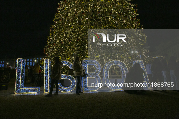 People gather around the Christmas lights at Praca do Comercio in Lisbon, Portugal, on December 14, 2024. The Christmas lights in Lisbon are...