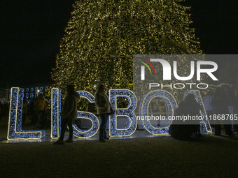 People gather around the Christmas lights at Praca do Comercio in Lisbon, Portugal, on December 14, 2024. The Christmas lights in Lisbon are...