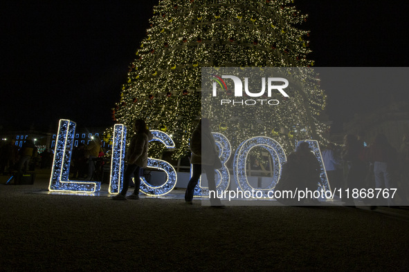 People gather around the Christmas lights at Praca do Comercio in Lisbon, Portugal, on December 14, 2024. The Christmas lights in Lisbon are...