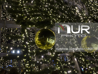 People are reflected around the Christmas lights at Praca do Comercio in Lisbon, Portugal, on December 14, 2024. The Christmas lights in Lis...