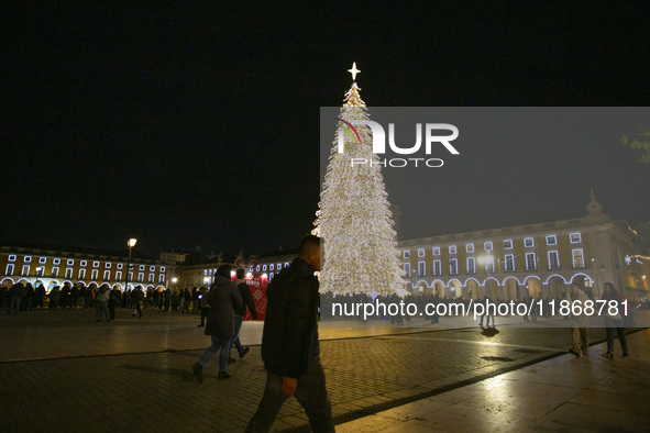 People gather around the Christmas lights at Praca do Comercio in Lisbon, Portugal, on December 14, 2024. The Christmas lights in Lisbon are...