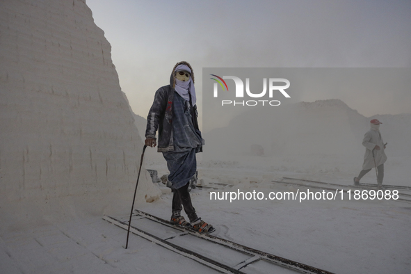 Labourers work at the ''White Mountain'' limestone extraction quarry site near Minya, Egypt, on December 14, 2024. Covered in fine white dus...