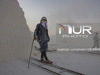 Labourers work at the ''White Mountain'' limestone extraction quarry site near Minya, Egypt, on December 14, 2024. Covered in fine white dus...