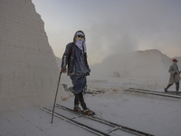 Labourers work at the ''White Mountain'' limestone extraction quarry site near Minya, Egypt, on December 14, 2024. Covered in fine white dus...