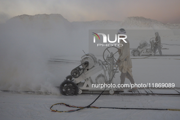 Labourers work at the ''White Mountain'' limestone extraction quarry site near Minya, Egypt, on December 14, 2024. Covered in fine white dus...