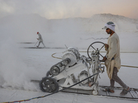 Labourers work at the ''White Mountain'' limestone extraction quarry site near Minya, Egypt, on December 14, 2024. Covered in fine white dus...