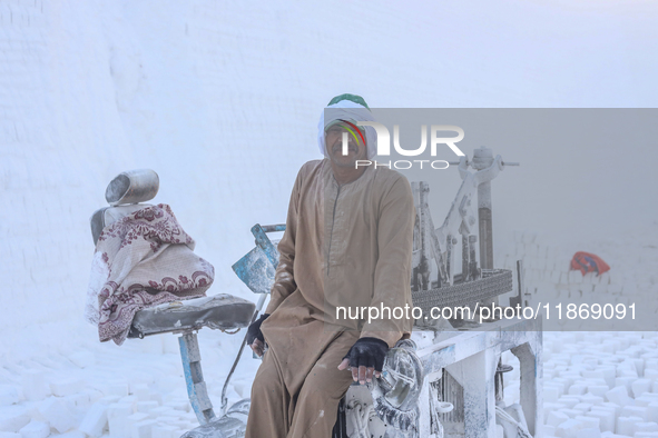 Labourers work at the ''White Mountain'' limestone extraction quarry site near Minya, Egypt, on December 14, 2024. Covered in fine white dus...