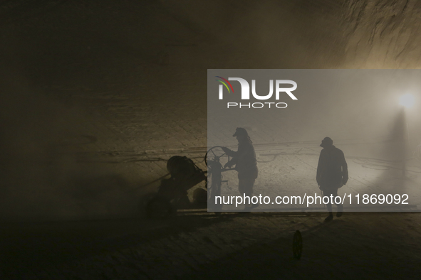 Labourers work at the ''White Mountain'' limestone extraction quarry site near Minya, Egypt, on December 14, 2024. Covered in fine white dus...