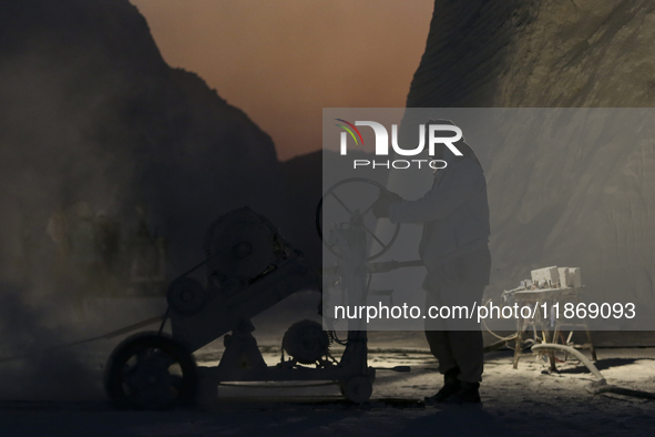 Labourers work at the ''White Mountain'' limestone extraction quarry site near Minya, Egypt, on December 14, 2024. Covered in fine white dus...