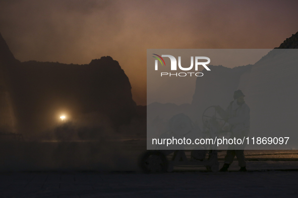 Labourers work at the ''White Mountain'' limestone extraction quarry site near Minya, Egypt, on December 14, 2024. Covered in fine white dus...