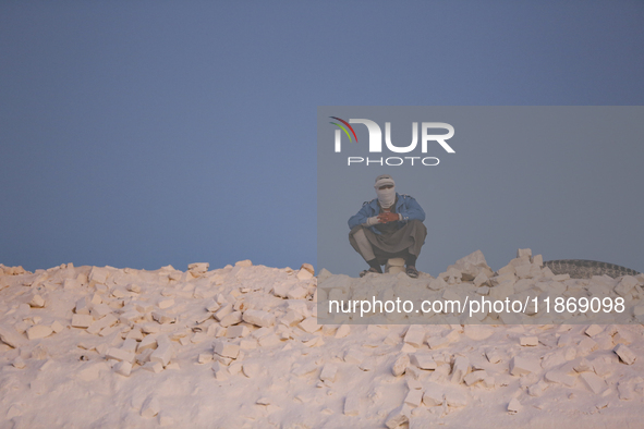 Labourers work at the ''White Mountain'' limestone extraction quarry site near Minya, Egypt, on December 14, 2024. Covered in fine white dus...