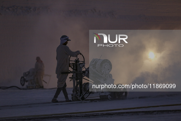 Labourers work at the ''White Mountain'' limestone extraction quarry site near Minya, Egypt, on December 14, 2024. Covered in fine white dus...