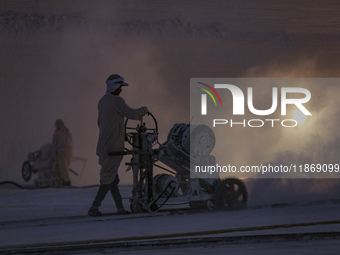 Labourers work at the ''White Mountain'' limestone extraction quarry site near Minya, Egypt, on December 14, 2024. Covered in fine white dus...