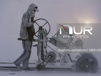 Labourers work at the ''White Mountain'' limestone extraction quarry site near Minya, Egypt, on December 14, 2024. Covered in fine white dus...