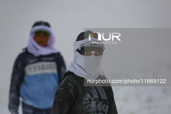 Labourers work at the ''White Mountain'' limestone extraction quarry site near Minya, Egypt, on December 14, 2024. Covered in fine white dus...