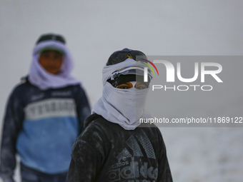 Labourers work at the ''White Mountain'' limestone extraction quarry site near Minya, Egypt, on December 14, 2024. Covered in fine white dus...