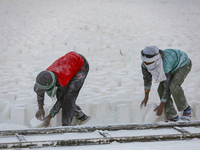 Labourers work at the ''White Mountain'' limestone extraction quarry site near Minya, Egypt, on December 14, 2024. Covered in fine white dus...