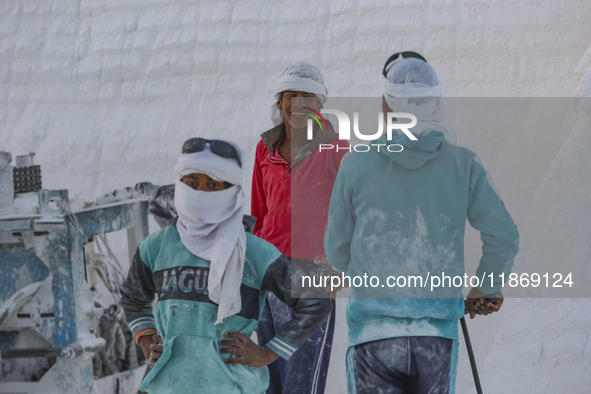 Labourers work at the ''White Mountain'' limestone extraction quarry site near Minya, Egypt, on December 14, 2024. Covered in fine white dus...