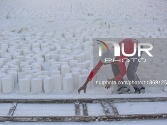 Labourers work at the ''White Mountain'' limestone extraction quarry site near Minya, Egypt, on December 14, 2024. Covered in fine white dus...