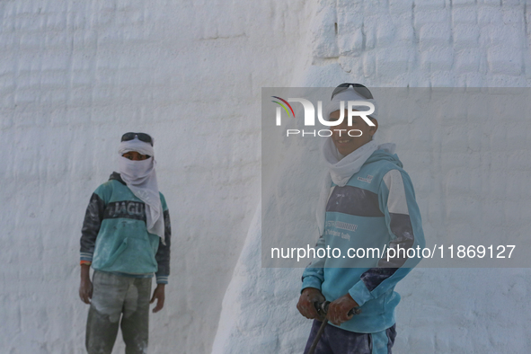 Labourers work at the ''White Mountain'' limestone extraction quarry site near Minya, Egypt, on December 14, 2024. Covered in fine white dus...