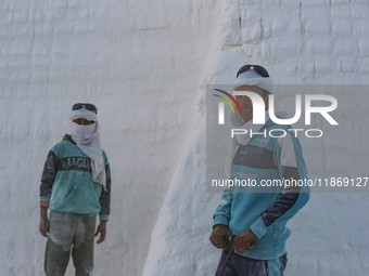 Labourers work at the ''White Mountain'' limestone extraction quarry site near Minya, Egypt, on December 14, 2024. Covered in fine white dus...